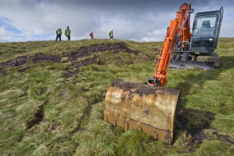 Digger and people on peatland