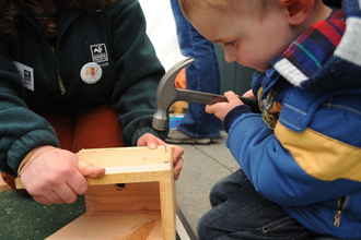 A child using a hammer safely under supervision