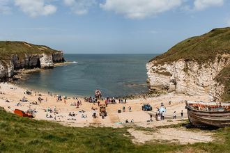 A sunny landscape photograph of the beach at Flamborough Cliffs