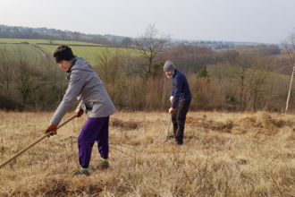 Volunteers raking hay at Hetchell Wood