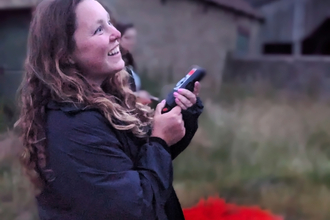 A young woman holds out a bat detector
