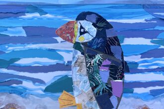 Collage puffin in foreground and collage textured blue sea and golden sand behind