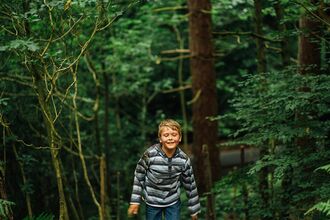 boy walking in a green woodland