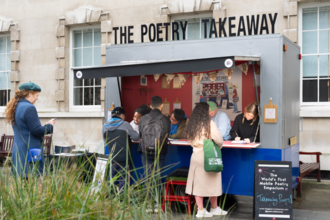 Customers gather outside a converted takeaway bus as poets writ on paper.