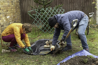 Two people creating a pond