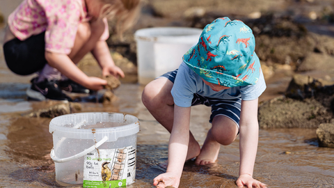 Two young children rockpooling on North Landing beach.
