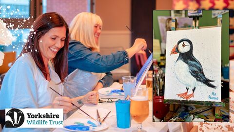 Image shows two people painting in a relaxed setting as well as a painted puffin on a canvas