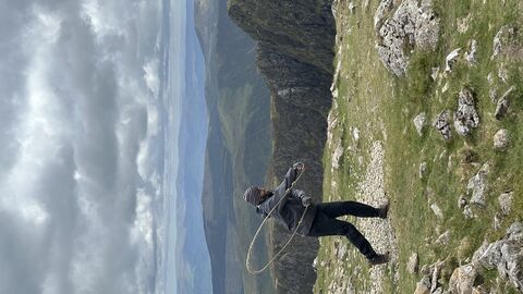 Person on top of mountain, swinging rope in flow