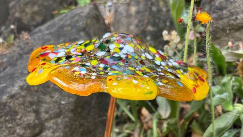 Glass toadstool ornament set amongst natural rocks