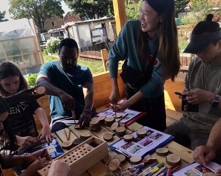 Group of students outdoors making wood cookies for nature