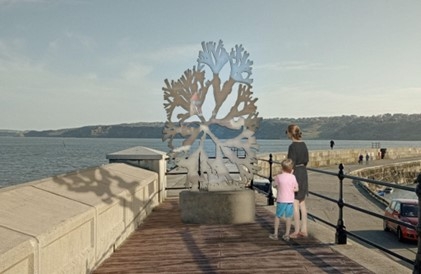 A metal seaweed sculpture positioned on the end of a harbour looking out to sea.