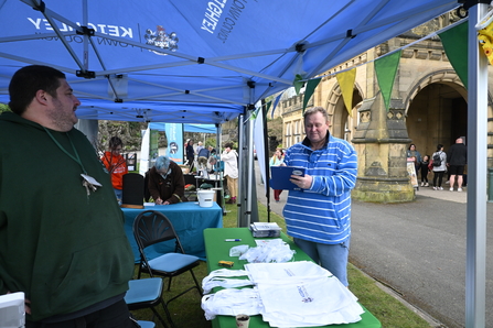 Action for Nature stalls with man holding clipboard