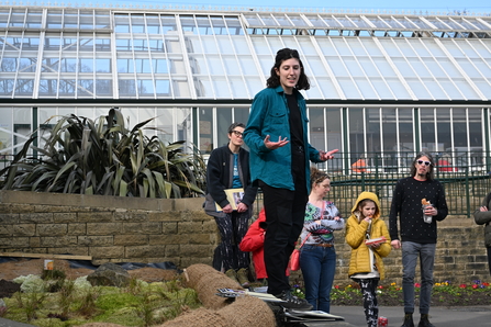 Woman giving talk next to a bog garden