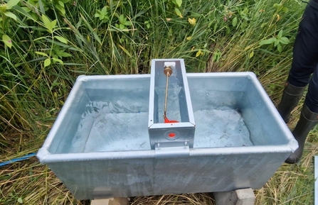 A small metal rectangular trough with running water