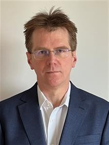 A man wearing glasses and a suit jacket