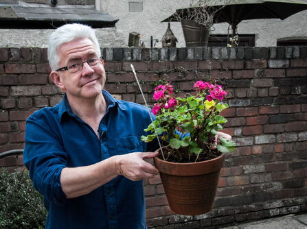 Ian McMillan holding a potted plant