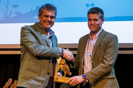 Robert McAneney, a man stood on the right, accepts an award from Wildlife Trusts CEO Craig Bennett (left)