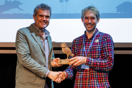 A representative from Forest of Flowers (right) accepts an award from Wildlife Trusts CEO Craig Bennett (left)