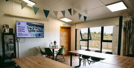 Meeting room with table and chairs and windows looking out on to reserve
