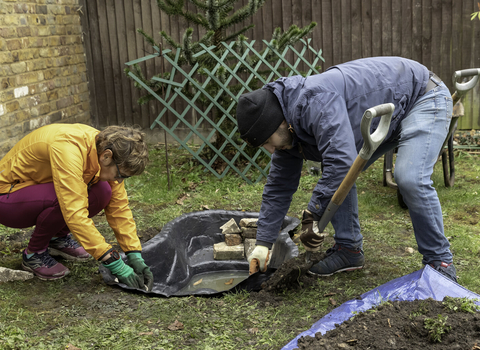 Two people creating a pond